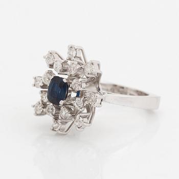 An 18K white gold ring set with a faceted sapphire and old-cut diamonds.