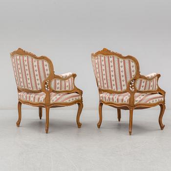 An end of the 19th Century rococo style walnut sofa with four chairs, two armchairs and a table.