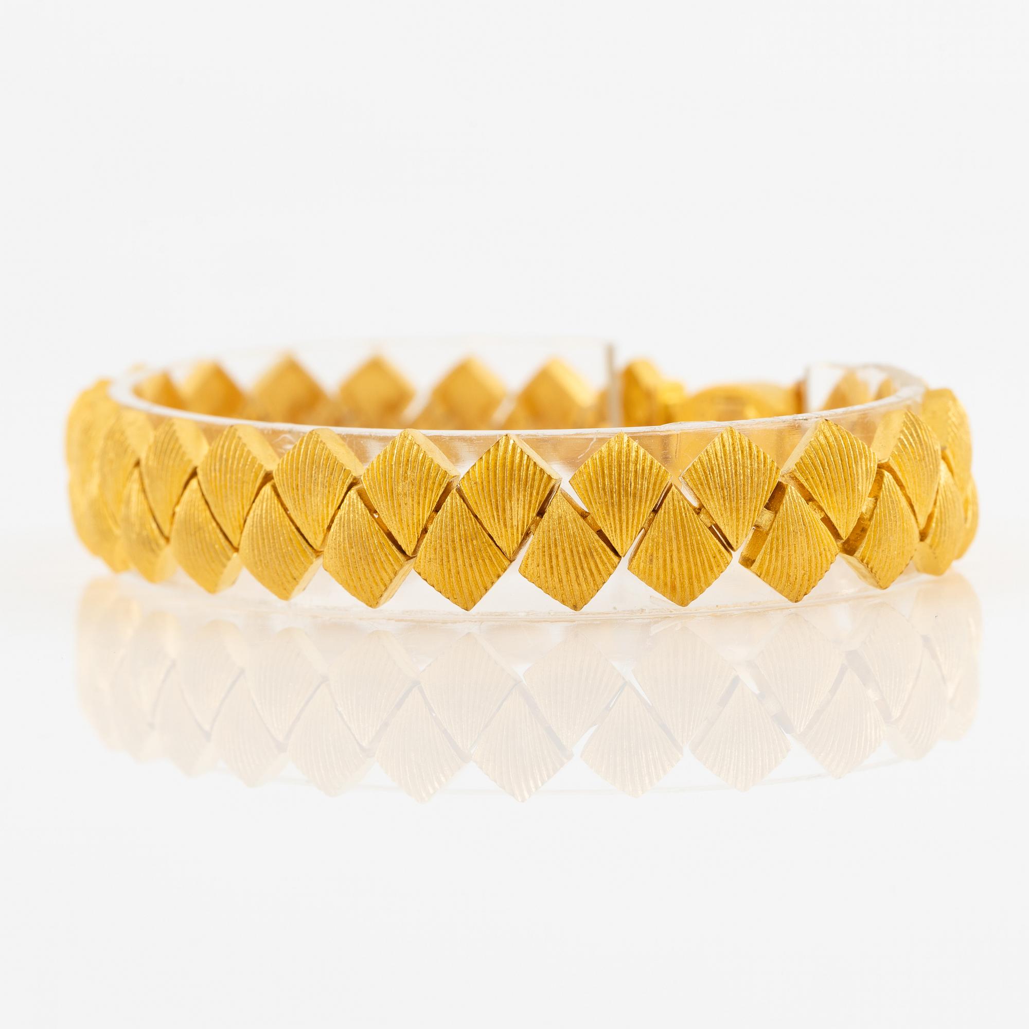 Garnityr av guldsmycken, en collier (14K), ett armband (18K), ett par örhängen (14K) och en ring (14K).