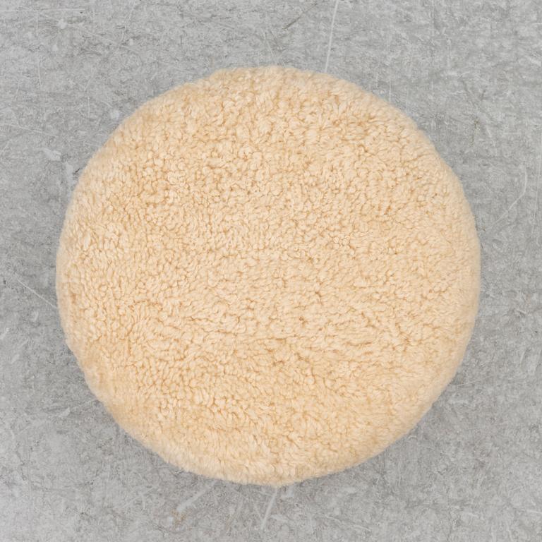 A contemporary stool with birch legs and new sheepskin upholstery.