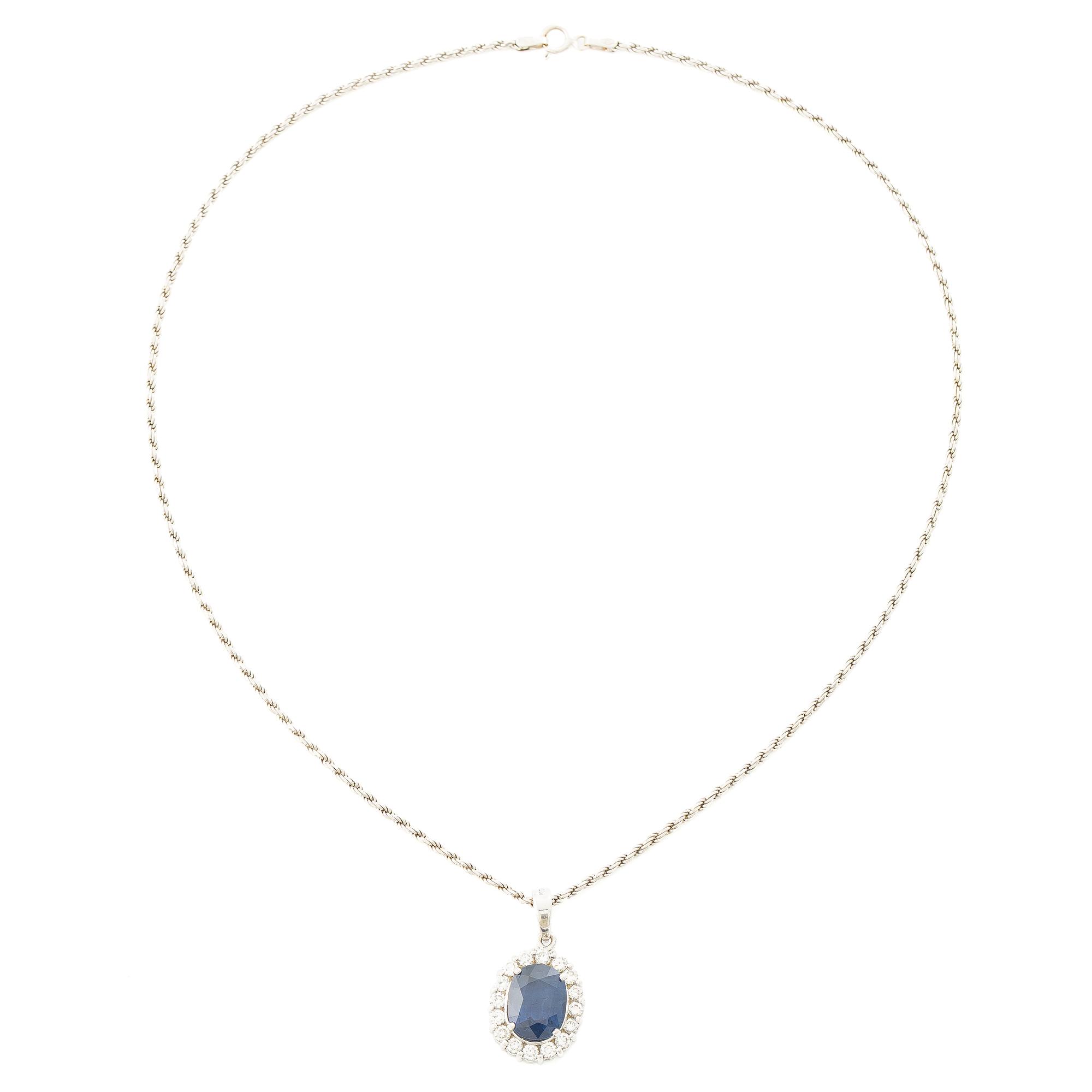 Pendant in 18K white gold with a faceted sapphire and round brilliant-cut diamonds.