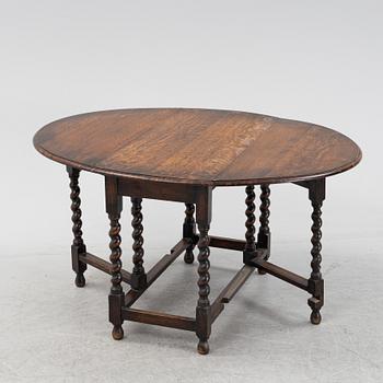 An oak baroque style gate leg table, 20th Century.