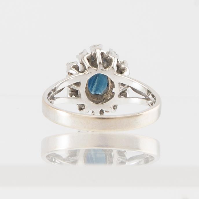 Ring 14K vitguld med en ovalt fasetterad safir samt runda briljantslipade diamanter.