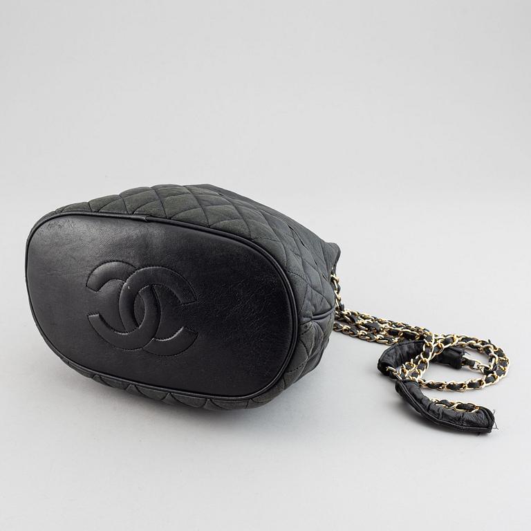 Chanel, a black leather drawstring bag.