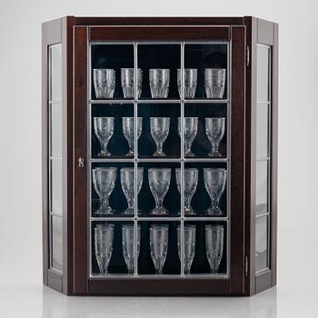 A display cabinet with a 47-piece glass service, "Koskull" from Kosta, Sweden.