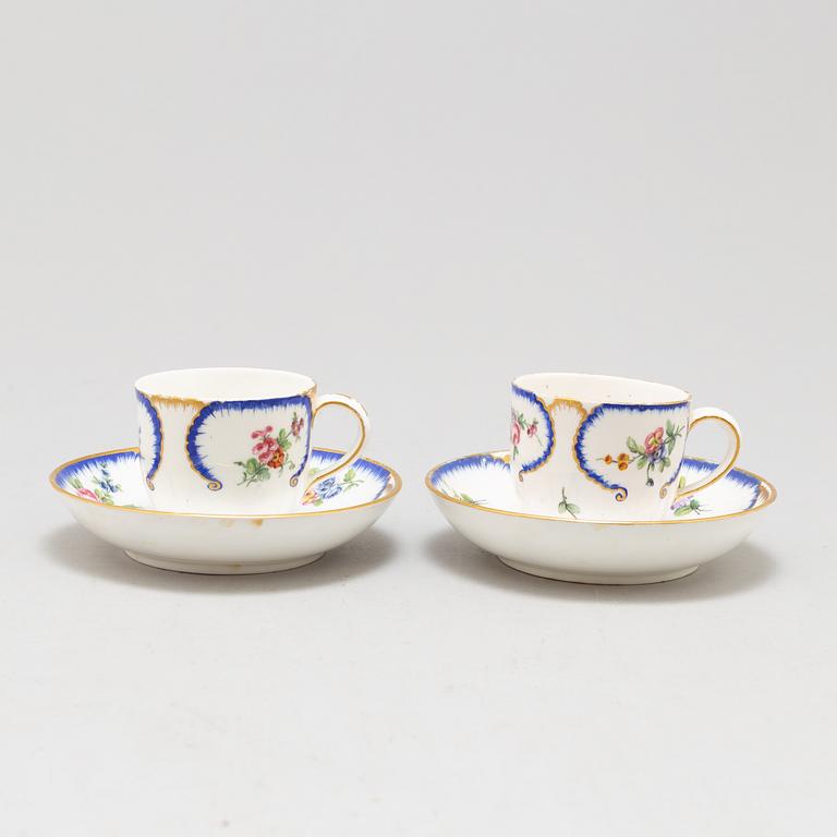 A pair of enamelled cups with dishes, France, Sèvres, 1780s.