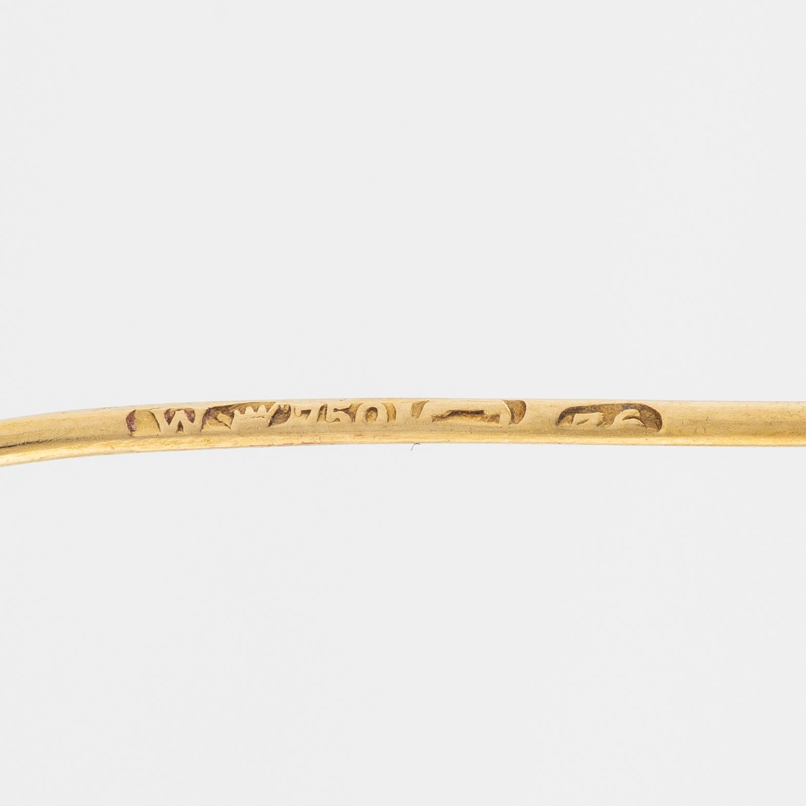 Brooch, 18K gold with cabochon-cut ruby, decoration of leaves.