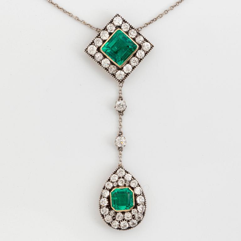 A necklace set with two faceted emeralds and old-cut diamonds.