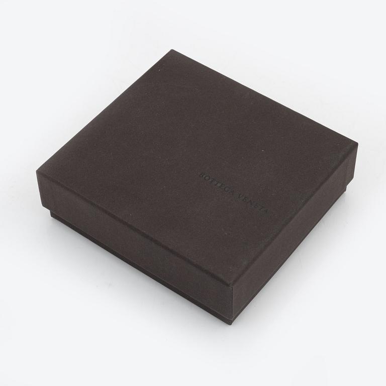 Bottega Veneta, a cerise leather wallet.