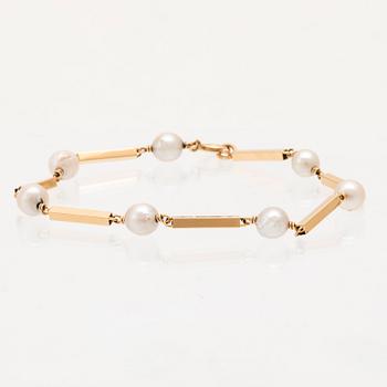 An 18K gold bracelet set with cultured pearls.