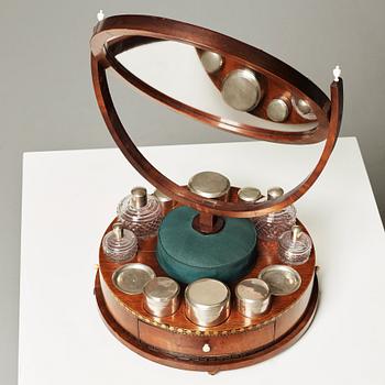 A Swedish Empire circa 1820 mirror on a stand for silver and glass toiletries.