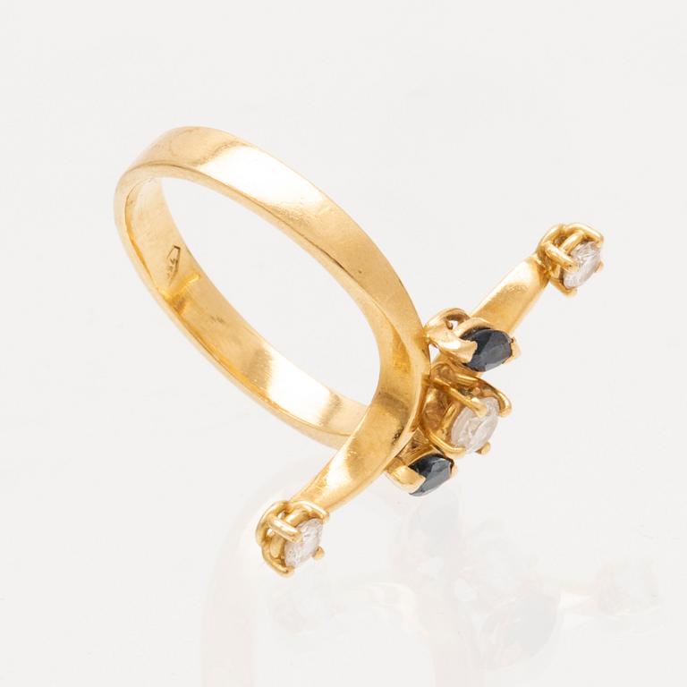 An 18K gold ring with marquise cut sapphires and round brilliant cut diamonds.