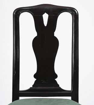 A set of eight black Swedish rococo chairs.