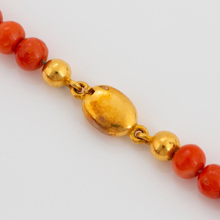 A coral necklace with a 14K gold clasp.