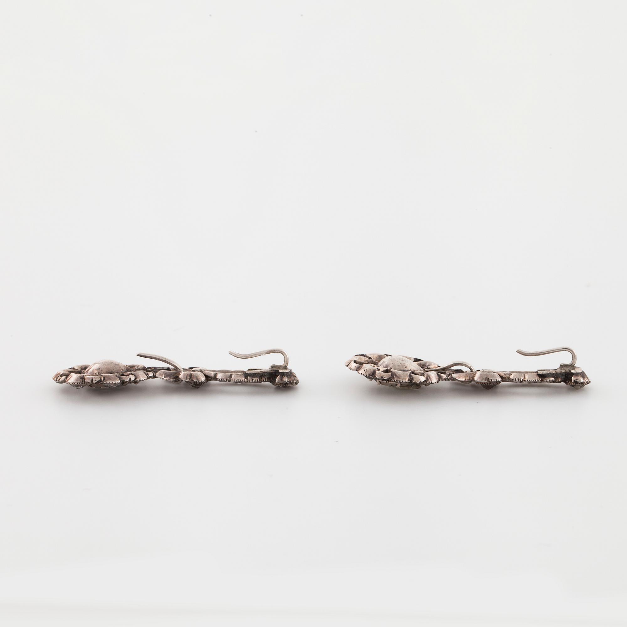 A pair of earrings and a brooch set with rose cut diamonds.