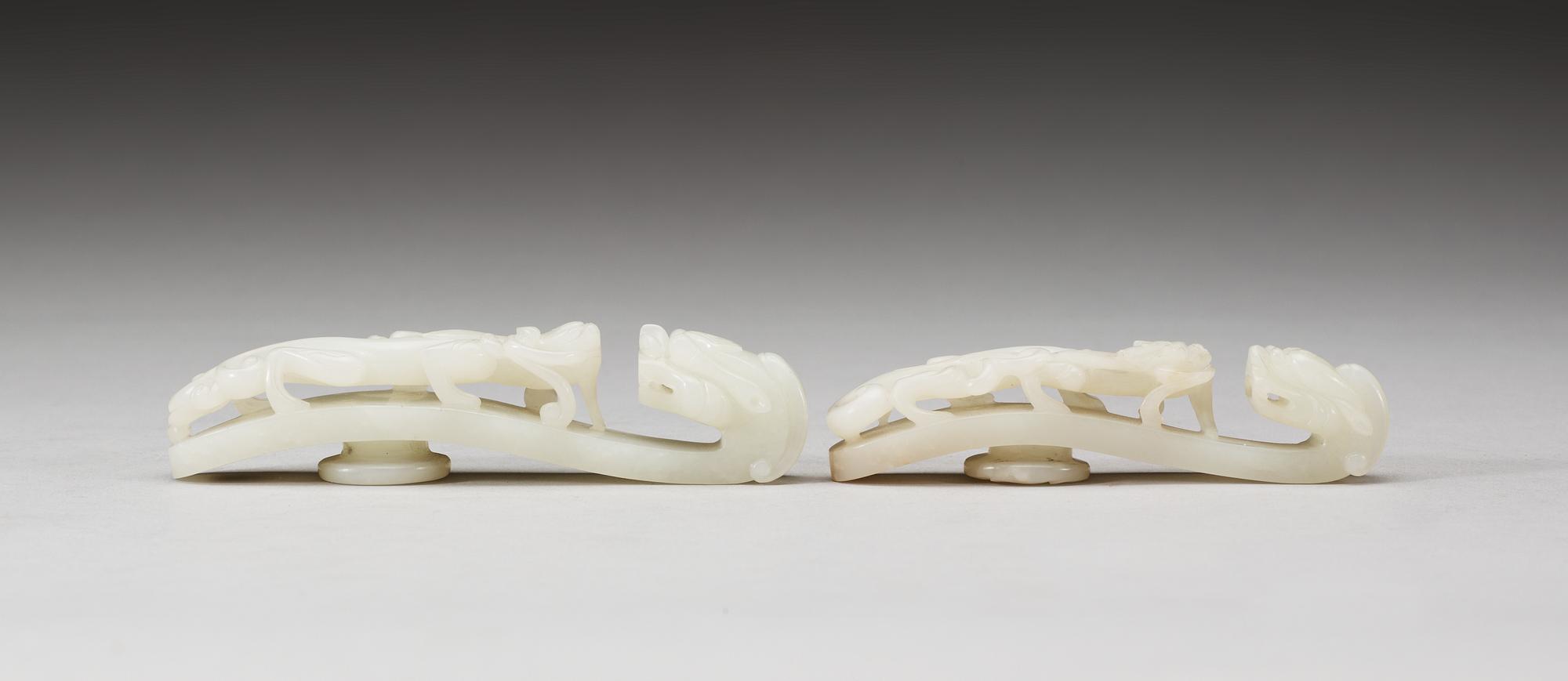Two pale green nephrite garment hooks, Qing dynasty.