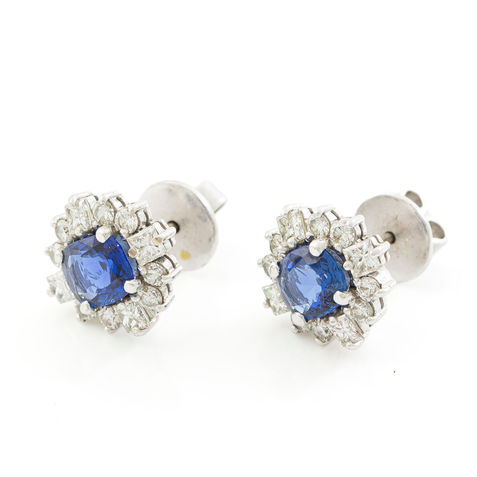 A pair of 14K gold earrings with faceted sapphires and round brilliant- and princess-cut diamonds.
