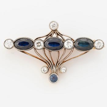 Brooch 18K gold and platinum set with step-cut sapphires and round brilliant-cut diamonds.