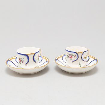 A pair of enamelled cups with dishes, France, Sèvres, 1780s.