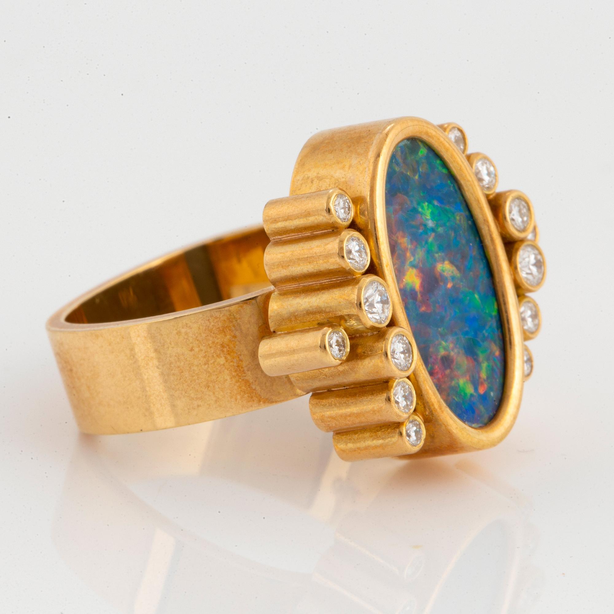 An 18K gold and opal ring set with round brilliant-cut diamonds.