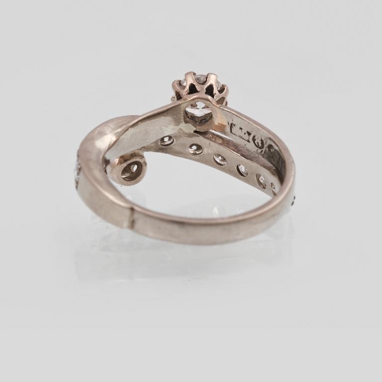RING, 18K guld med 2 större briljantslipade diamanter ca 0.60 ct vardera samt 11 st mindre totalt ca 1.10 ct. Vikt 7,3 g.