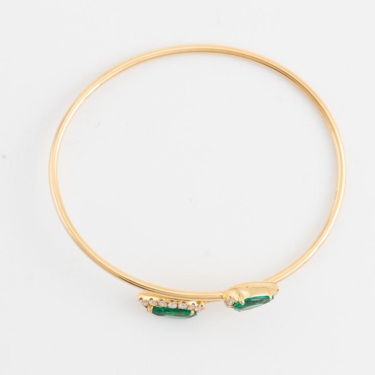Pear shaped emerald and brilliant cut diamond cross over bangle.