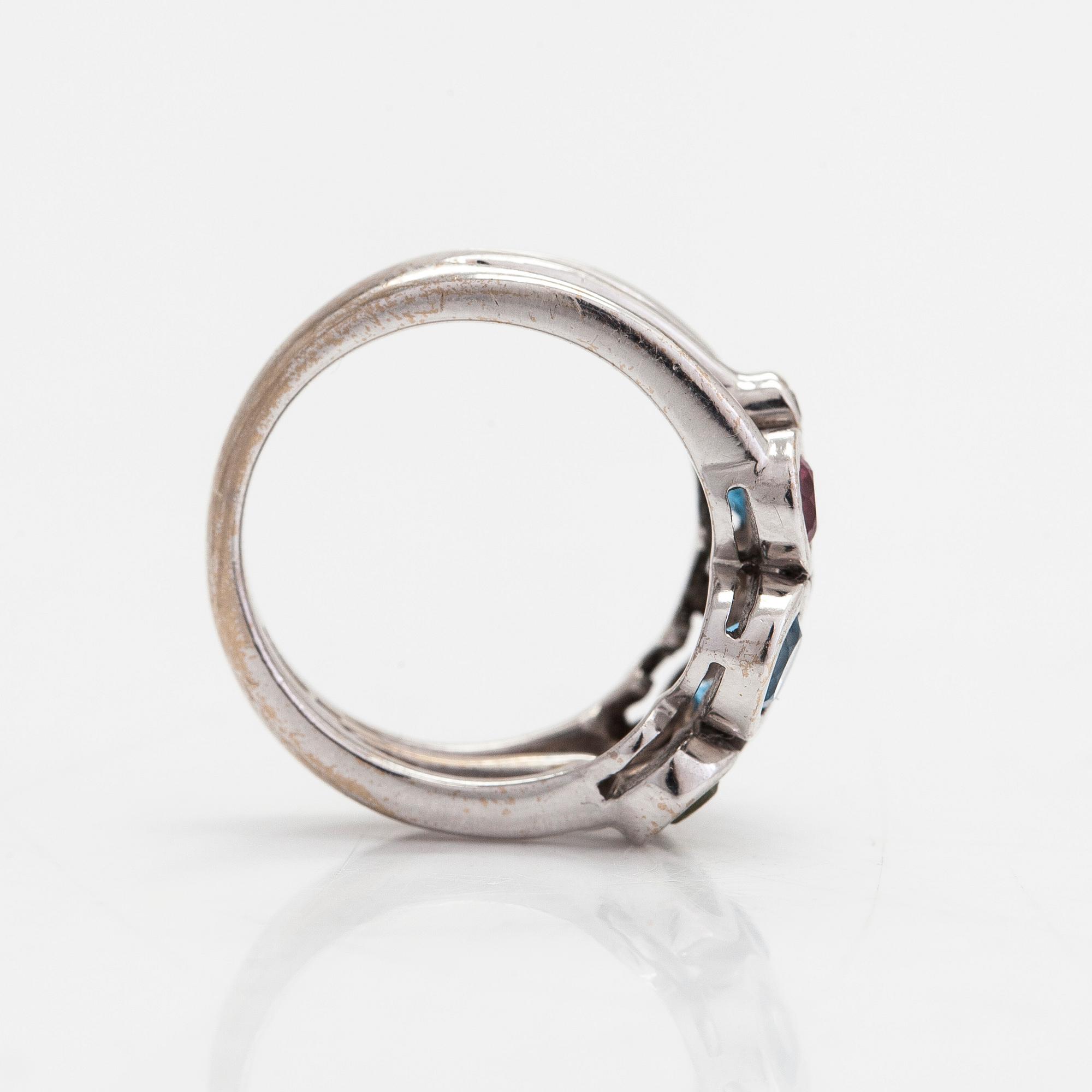Cassandra Goad, sormus, "Cirkel", 18K valkokultaa, timantteja noin 0.08 ct ja monivärisiä jalokiviä. Lontoo.