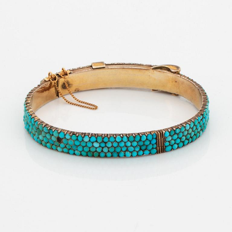 A silver and turquoise bracelet.