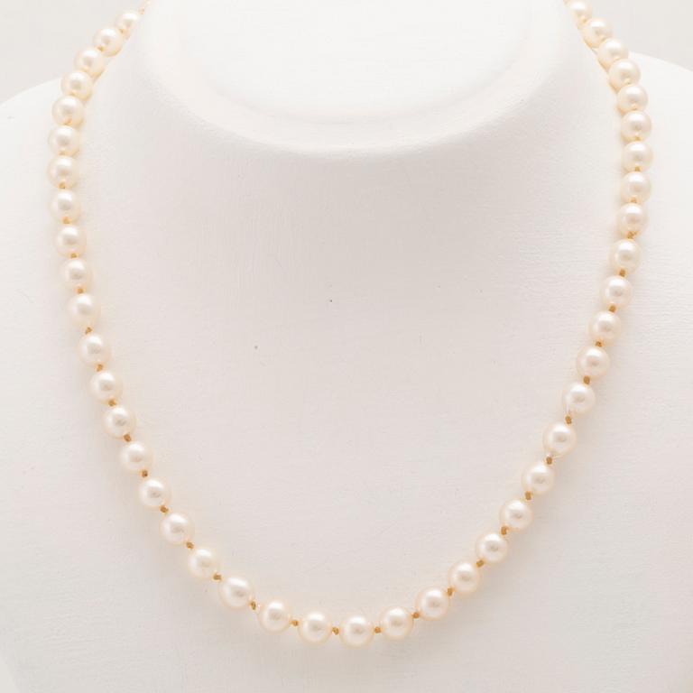 A necklace of cultured pearls with an 18K white gold lock set with single cut diamonds.