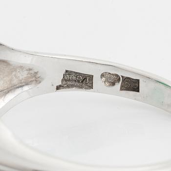 An 18K white gold ring set with a cabochon-cut emerald and eight-cut diamonds.