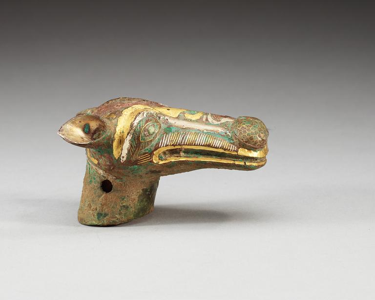 An archaistic bronze handle for a cane in the shape of a mythological animal.