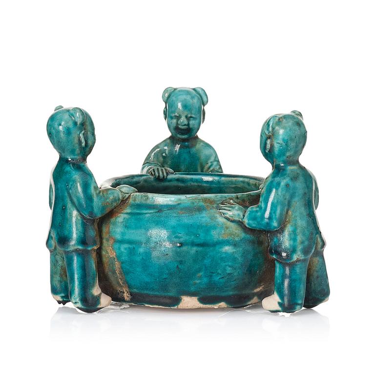 A turquoise glazed vessel supported by a group of boys, Qing dynasty, Kangxi (1662-1722).