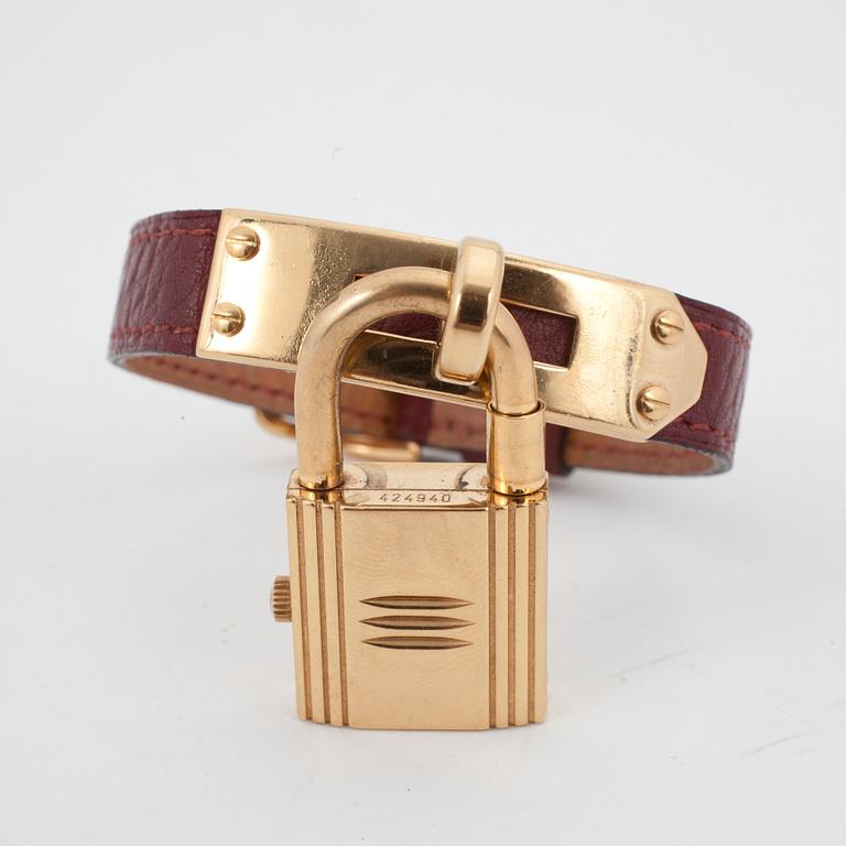 HERMÈS, a burgundy red leather braclet with 14k gold plated watch, "Kelly Lock".