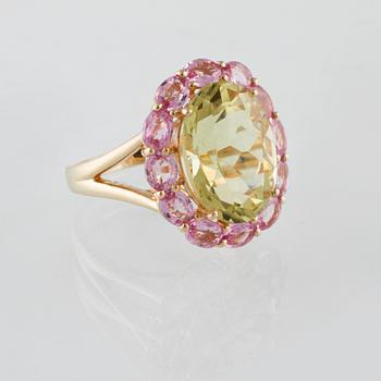 RING, 18K guld med ovalslipad topas ca 6.21 ct samt rosa safirer ca 2.25 ct. Vikt 6,2 gram.