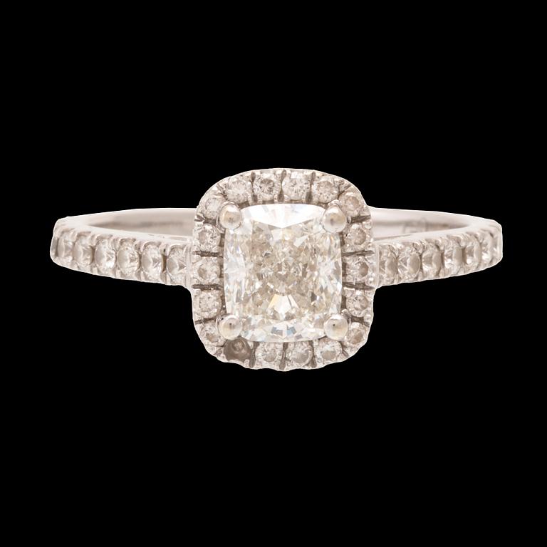 An 18K white gold ring set with a modified cushion-cut diamond and round brilliant-cut diamonds.