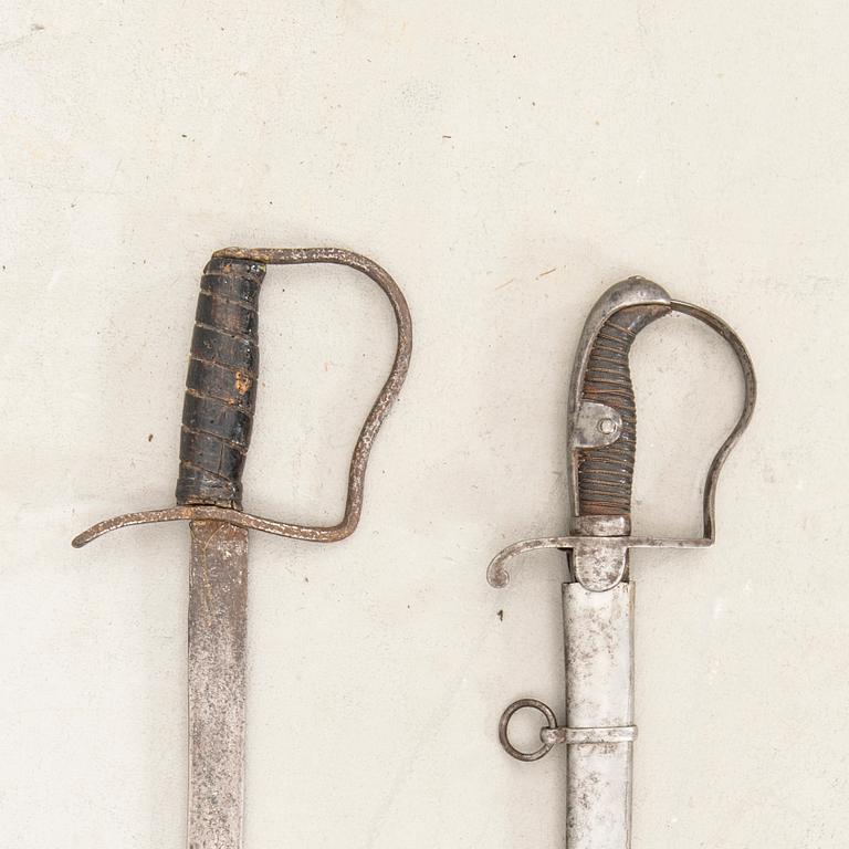 A German sabre with scabbard and a cutlass.