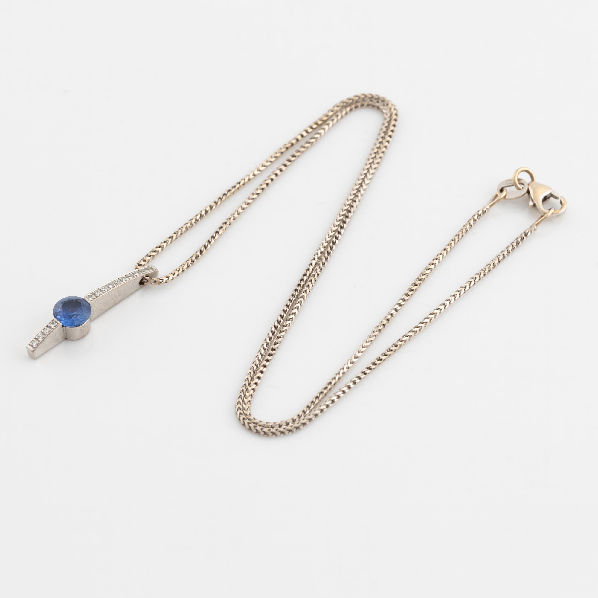 An 18K white gold necklace with a faceted sapphire and brilliant cut diamonds.