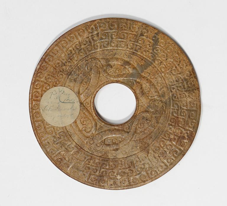 A jade Archaistic Bi disc with a wooden stand, Qing dynasty (1644-1912).