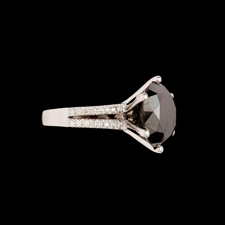 RING, 18 k vitguld, svart briljantslipad diamant 11.74 ct, samt 36 mindre briljanter tot ca 0.32ct.