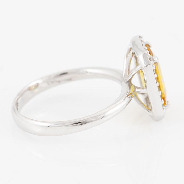 Ring 18K guld med en fasettslipad safir och runda briljantslipade diamanter.