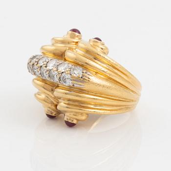 An 18K gold ring set with round brilliant-cut diamonds and cabochon-cut rubies.