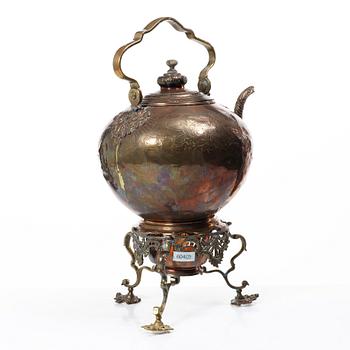 A German Rococo repoussé copper teapot on rechaud, mid 18th century.