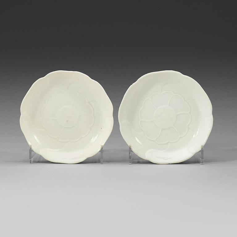 A pair of white-glazed small moulded dishes, Qing dynasty, Yongzheng six-character mark and of the period.