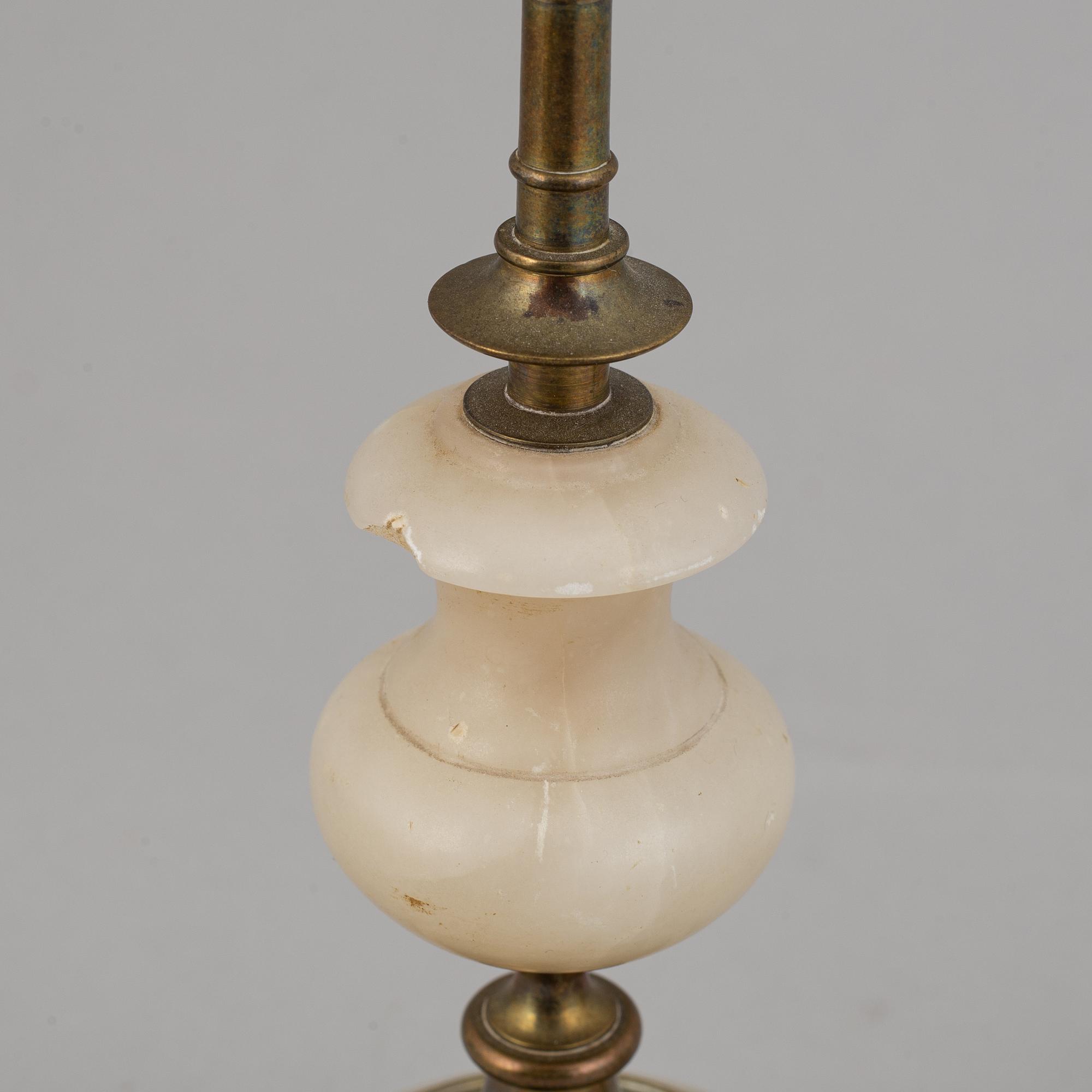 An alabaster mantle clock and pair of candlesticks, circa 1900.