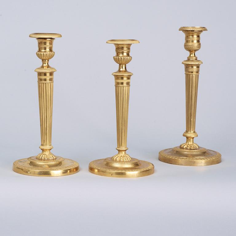 A matched pair Empire early 19th century gilt bronze candelabra/candlesticks. Including one empire candlestick.