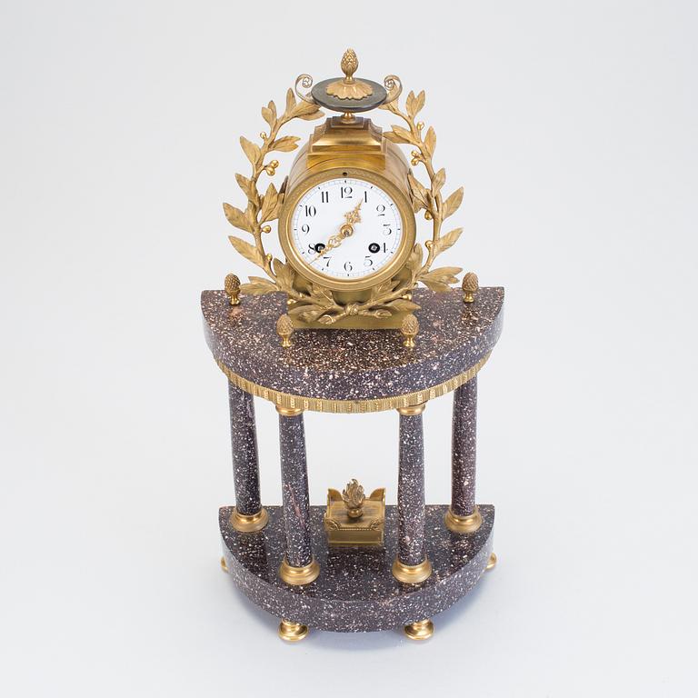 A Swedish Gustavian style porphyry and gilt bronze mantel clock from around year 1900.