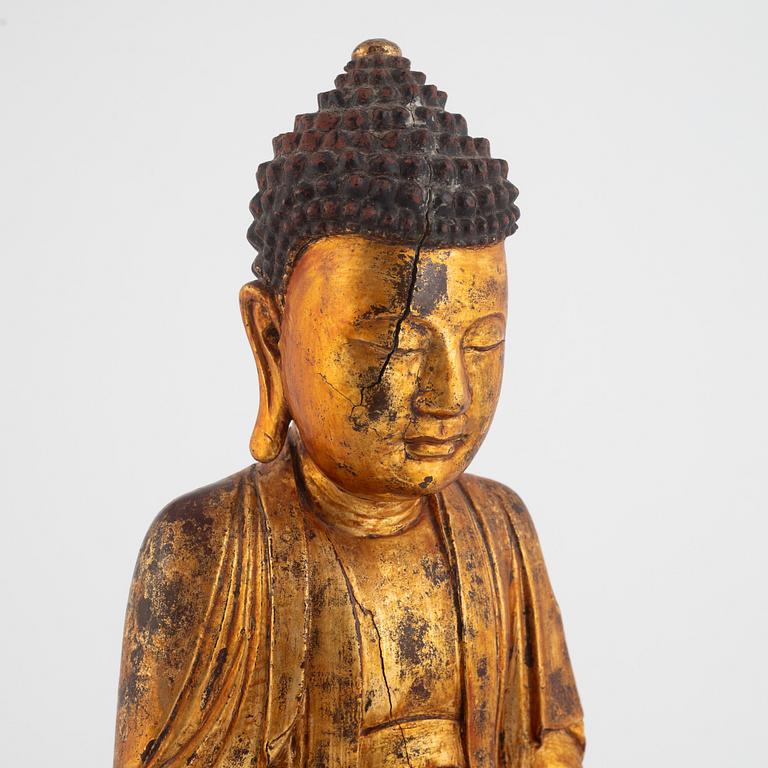 A gilt and lacquered figure of a seated buddha, late Qing dynasty.