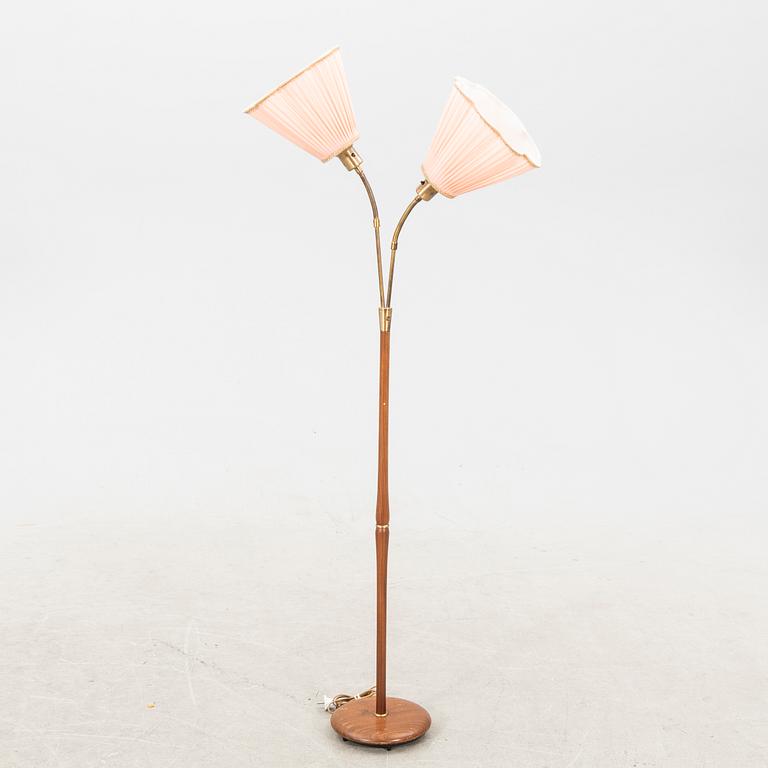 A teak and brass floor lamp from the first half of the 20th century.