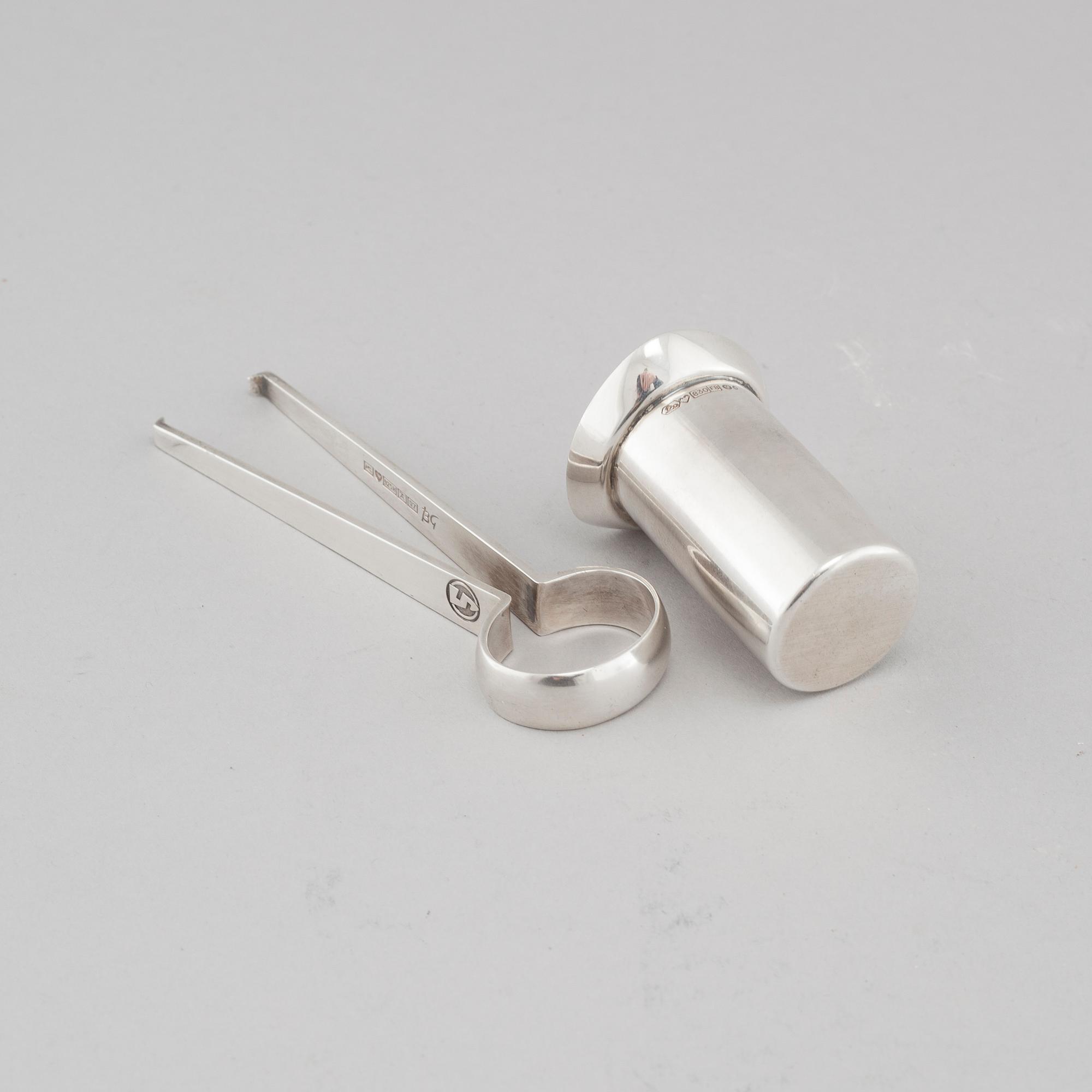 Two silver drink accessories with finnish stamps.