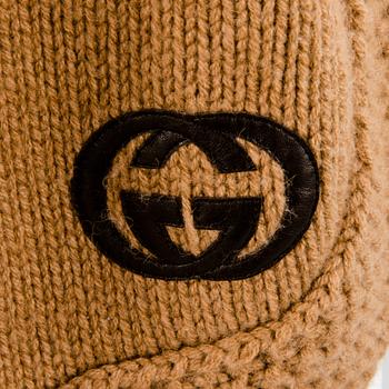 GUCCI, CAMEL HAIR PONCHO AND A HAT.